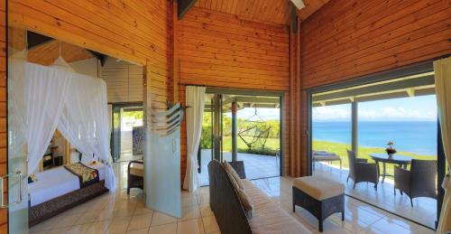 a room with a bedroom with a view of the ocean at Taveuni Island Resort & Spa in Matei