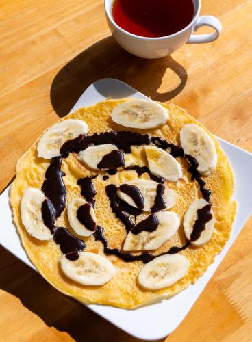 a pancake with chocolate and banana slices on a table at Green Homestay in Cat Ba
