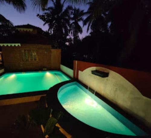 a swimming pool at night with a water slide at Blue Sea Beach Resort Malvan in Malvan