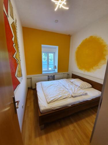 ein Schlafzimmer mit einem Bett mit gelber Wand in der Unterkunft Ferienwohnung am Trausdorfberg - Rosenblick in Goggitsch in Steiermark