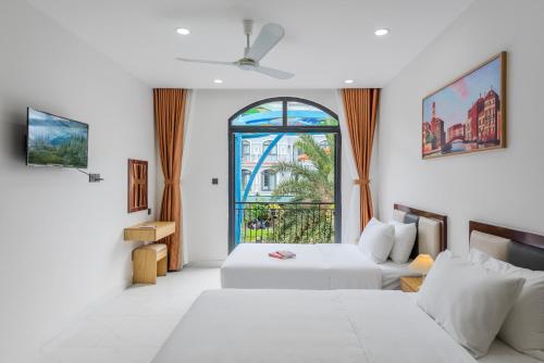 a hotel room with two beds and a window at 222 ROSÉ Hotel in Phú Quốc