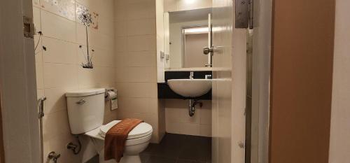 Prom Ratchada Hotel - SHA Plus في بانكوك: حمام صغير مع مرحاض ومغسلة