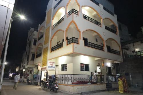 a building with people standing outside of it at night at Hotel laxminarayan in Shirdi