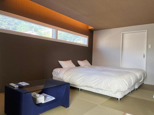 a bedroom with a bed and a table and a window at Stay`sOTARU in Otaru