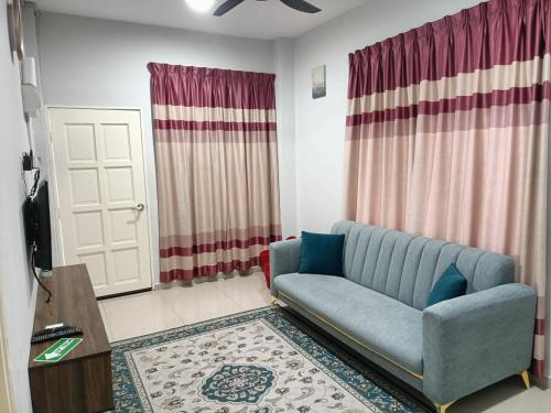 RINA HOMESTAY Kemaman في Cukai: غرفة معيشة مع أريكة زرقاء وباب