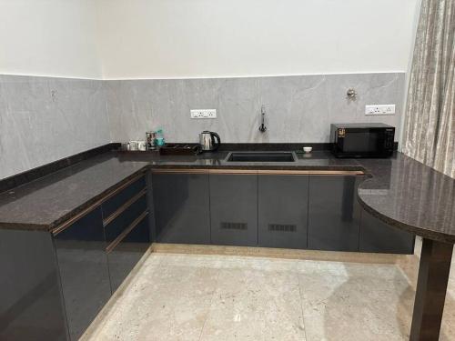 a kitchen with a sink and a counter top at Passaddhi Serviced Apartment T2 in Mysore