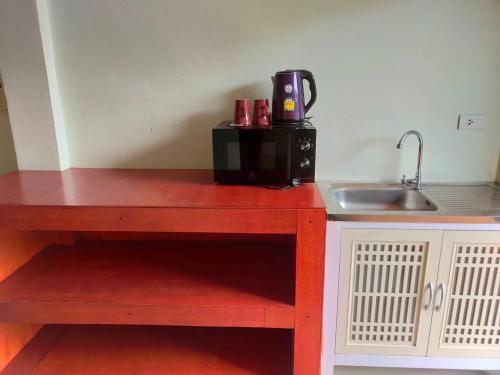a kitchen counter with a microwave and a sink at Goh Residence in Chaweng