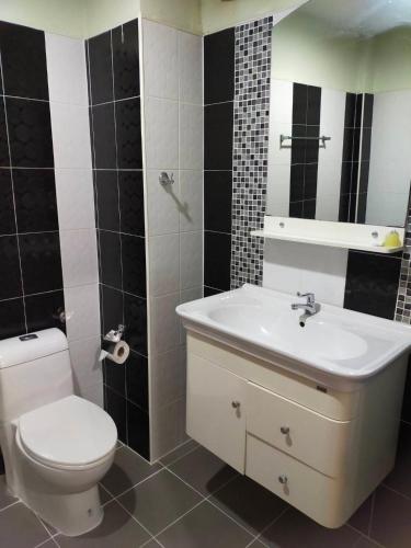 a bathroom with a white toilet and a sink at Goh Residence in Chaweng