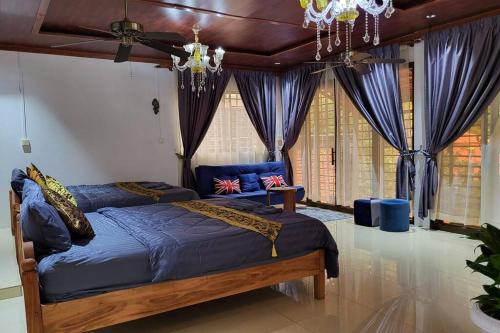 - une chambre dotée d'un grand lit avec des draps bleus et des rideaux dans l'établissement CL Homestay, à Saen Monourom