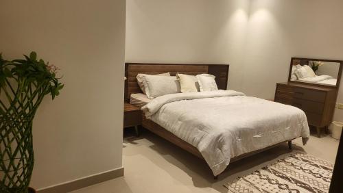 شقة فاخرة VIP حي الوادي في الرياض: غرفة نوم مع سرير وخزانة مع مرآة