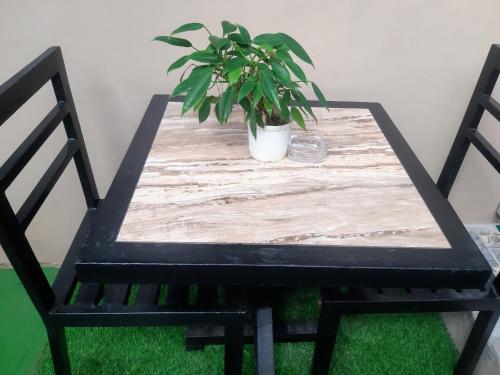 a wooden table with a potted plant on a chair at Casa Erelle -1 Bedroom guest house #2 in Antipolo