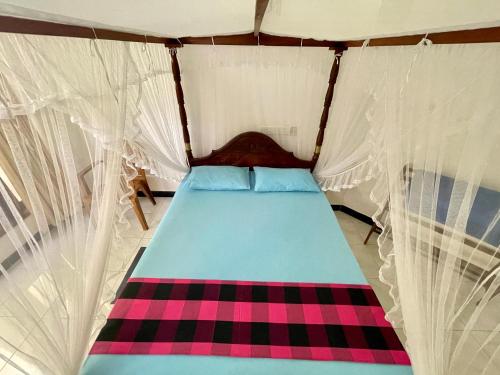 a bed in a tent in a room at Sun & Tree HomeStay (With Green Nature View) in Mirissa