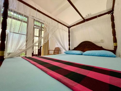 sypialnia z dużym łóżkiem z niebieskimi poduszkami w obiekcie Sun & Tree HomeStay (With Green Nature View) w mieście Mirissa