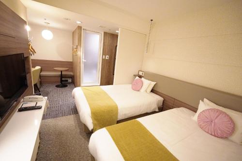 a hotel room with two beds and a flat screen tv at Matsue New Urban Hotel in Matsue