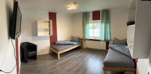 a room with two beds and a tv in it at Zimmer 4 in Bullendorf