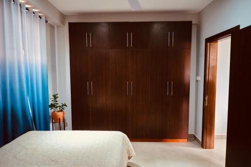 um quarto com uma cama e um armário de madeira em The Pearls em East Legon