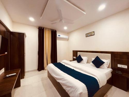 um quarto com uma cama grande e almofadas azuis em The White House Haridwar em Haridwār