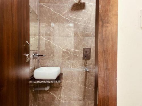uma casa de banho com um chuveiro e um WC. em The White House Haridwar em Haridwar