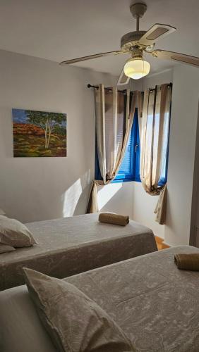 a bedroom with two beds and a window at The Beach Penthouse in Torrox Costa