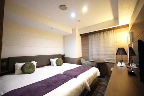 Postel nebo postele na pokoji v ubytování Matsue New Urban Hotel