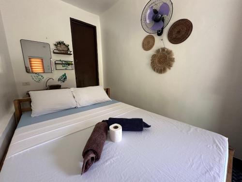 a bed with a towel and a roll of toilet paper on it at Tribal Xperience Guesthouse in San Vicente