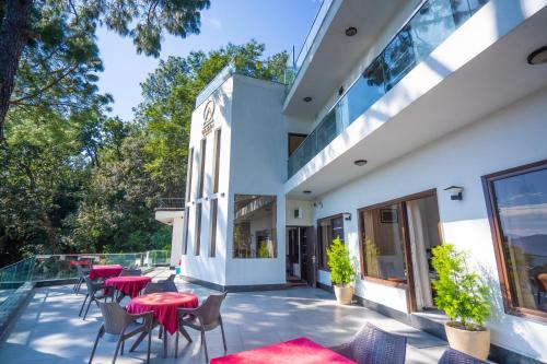a patio with tables and chairs on a building at The Golden Sunrise Hotel in Nainital