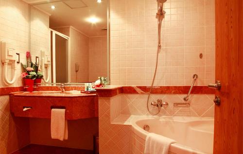 a bathroom with a tub and a sink at Moscow Hotel in Dubai
