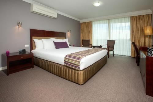 a hotel room with a bed and a desk at Hotel Gloria in Springwood