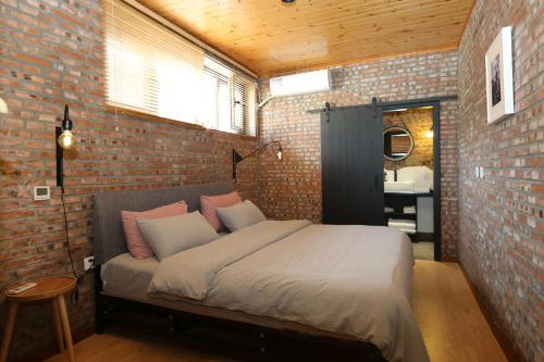 1 dormitorio con 1 cama en una pared de ladrillo en Beijing MutianyuGreat Wall Let'sgo coffee&homesty en Huairou