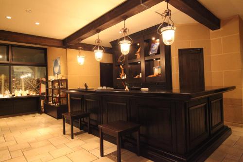a bar in a room with stools and lights at La Vista Daisetsuzan in Higashikawa