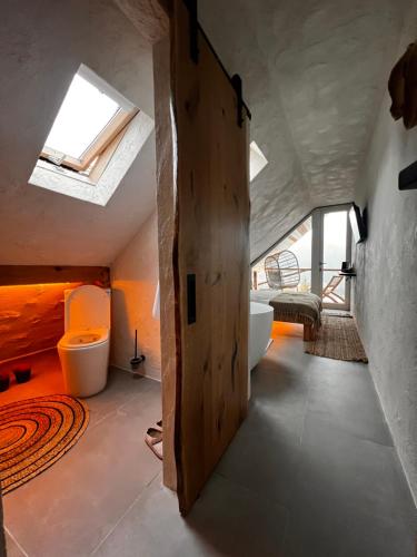 a bathroom with a wooden door and a bath tub at Shard Boutique Hotel-adult only in Braşov
