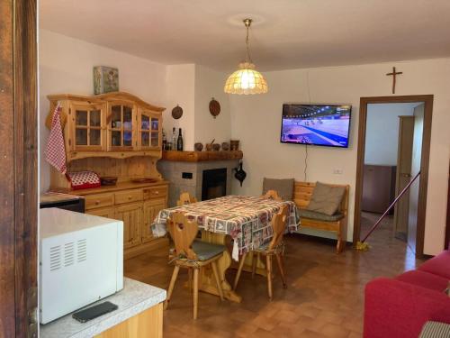 Il comprend une cuisine et une salle à manger avec une table et une télévision. dans l'établissement Aprica Sports and Relax, à Villa di Tirano