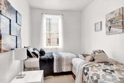 a white room with a bed and a couch at Cozy 2br Near Bella Vista Philly By Center City in Philadelphia