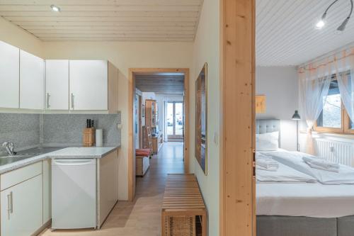 une cuisine et une chambre avec un lit dans une pièce dans l'établissement Apartment Auszeit - mitten im Ski- und Wandergebiet Spitzingsee, à Schliersee
