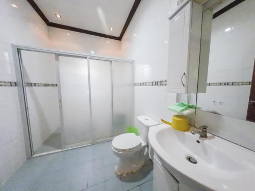 a bathroom with a shower and a toilet and a sink at Sunrise Guesthouse and Inn, Panglao in Panglao Island