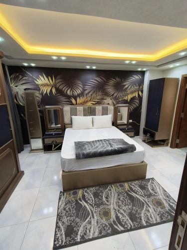 a bedroom with a bed and a painting on the wall at wow super lux apartment near to Nile شقة سوبر لوكس جديدة جامعة الدول العربية المهندسين in Cairo