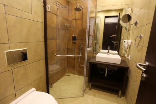 uma casa de banho com um chuveiro, um WC e um lavatório. em Sinon Baga Retreat em Baga