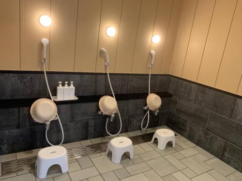 a bathroom with three urinals and three toilets at Garden House Umenoya Otaru in Otaru