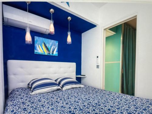- une chambre avec des murs bleus et un lit avec deux oreillers dans l'établissement 45 Croisette, à Cannes