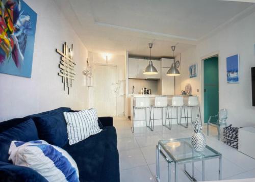 un salon avec un canapé bleu et une cuisine dans l'établissement 45 Croisette, à Cannes
