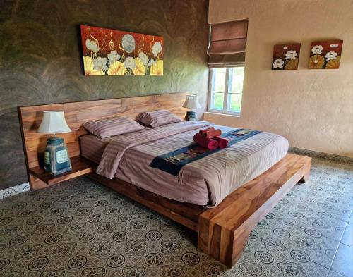 a bedroom with a bed with a teddy bear on it at Phoo Na Resort in Chiang Mai