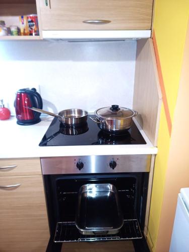 two pots on top of a stove in a kitchen at "Maria Luisa" - Top center apartment in Sofia
