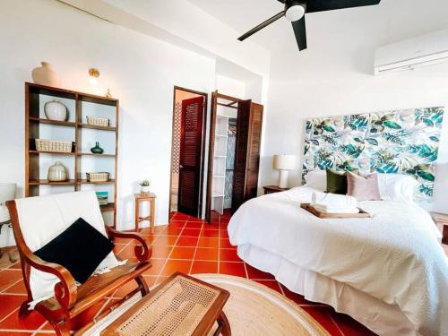 1 dormitorio con 1 cama blanca grande y 1 silla en Hiddem Gem w/ Ocean View & Rooftop @ Old San Juan en San Juan
