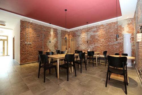 a dining room with brick walls and tables and chairs at Beijing MutianyuGreat Wall Let'sgo Hotel&Bar in Huairou