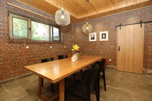 a dining room with a wooden table and chairs at Beijing MutianyuGreat Wall Let'sgo Hotel&Bar in Huairou