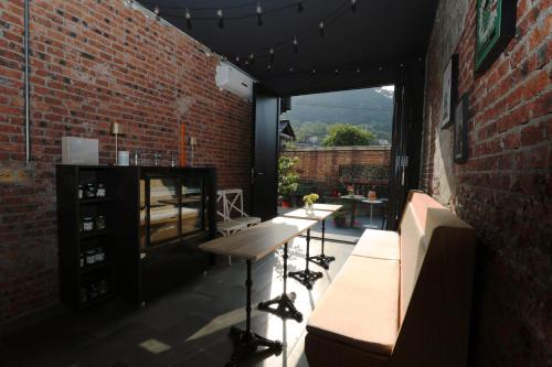 a patio with tables and a brick wall at Beijing MutianyuGreat Wall Let'sgo Hotel&Bar in Huairou