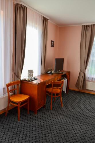 an office with a desk with two chairs and a computer at Viešbutis Ventainė in Ventė