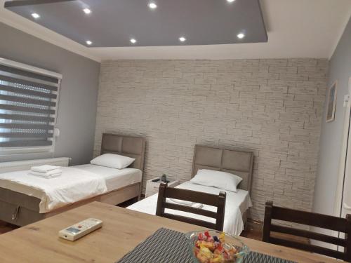 a room with two beds and a table with a bowl of fruit at Čavić apartmani in Vršac
