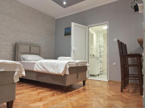 a bedroom with a large bed and a glass door at Čavić apartmani in Vršac