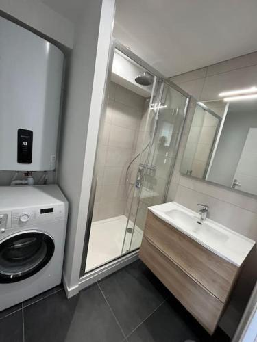une salle de bain avec douche et lavabo et une machine à laver dans l'établissement Bellevue - Appartement 60 m2 - 3 ch - vue mer - rénové à Wimereux Plage !, à Wimereux